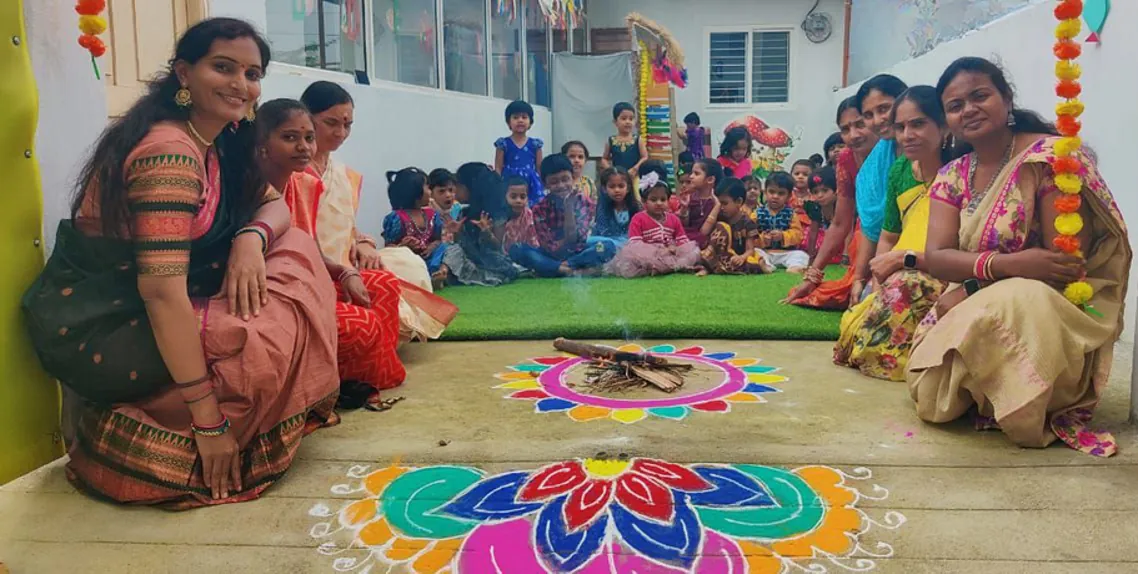 Parents and children making a rangoli together