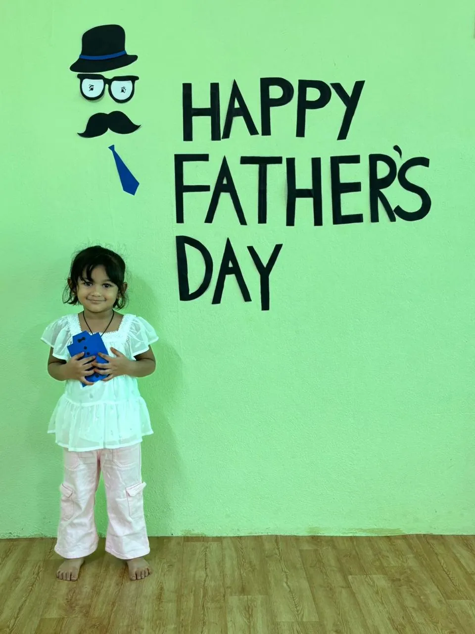 A child holding a handmade Father's Day card