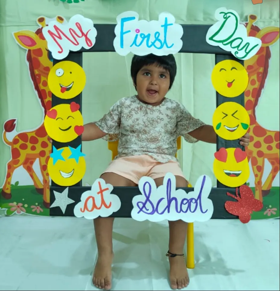 A child seated in the 'My First Day at School' frame